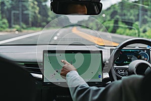 Hand using touchscreen navigation in electric car