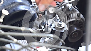 Hand using a wrench to loosen the nut of car