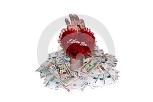 Hand with valentine heart on a background of heaps of money