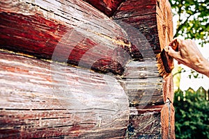 Hand varnishing of wooden house facade closeup