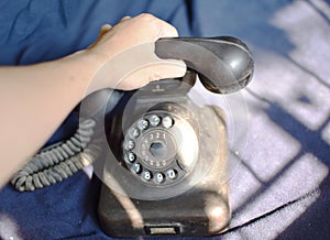 Hand on vintage phone blue background