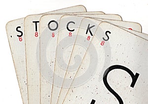 A hand of vintage playing cards spelling the word STOCKS.