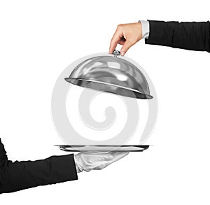 The hand of the waiter holding cloche over empty photo