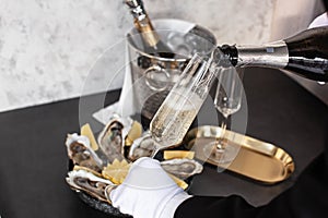 Hand of waiter with white glove pouring champagne