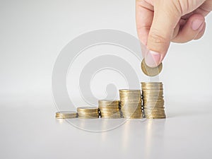 The hand was picking up the money that had been stacked up in layers. White background