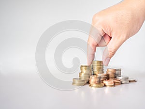 The hand was picking up the money that had been stacked up in layers. White background