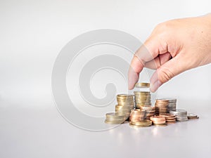 The hand was picking up the money that had been stacked up in layers. White background