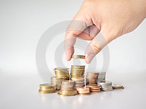 The hand was picking up the money that had been stacked up in layers. White background