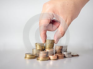 The hand was picking up the money that had been stacked up in layers. White background