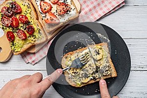 The hand was using a knife and fork to cut the banana Toast. Concept of healthy eating, dieting, vegan vegetarian food