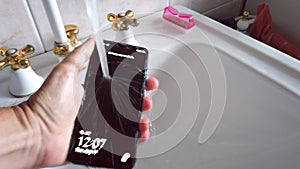 Hand wash mobile phone under tap water against covid 19 , coronavirus and bacteria