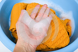 Hand washing of delicate woolen knitted clothes, sweaters concept