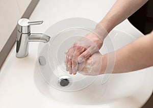Hand washing. A man washes his hands with soap close up. Personal hygiene and health care concept