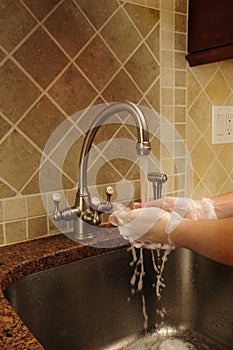 Hand washing and rinsing soapy water at a sink photo