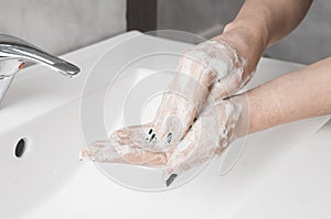 Hand washing techniques: woman rub the palm of her hand with fingertips of the other hand