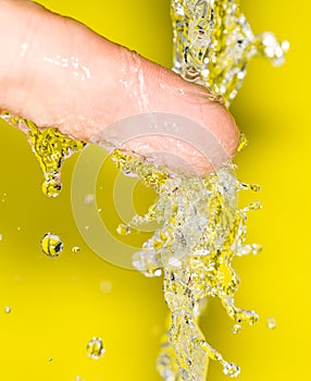 Hand in the water on a yellow background