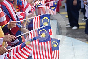 Hand waving Malaysia flag also known as Jalur Gemilang in conjunction with the Independence Day celebration or Merdeka Day. photo