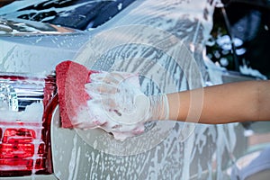 Hand wear gloves of hold sponge over the car for washing, Car wash service concept