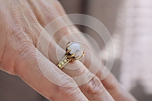 hand wearing brass ring with shiny moonstone gemstone