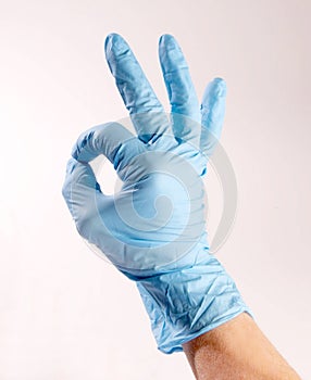 Hand wearing PPE signing OK