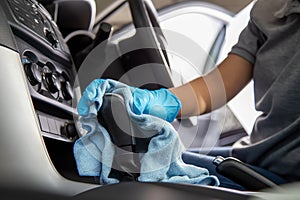 Hand wearing rubber gloves cleaning gear lever or gear shifter with microfiber cloth, Clean the car interior