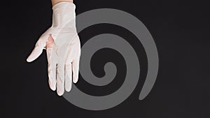 Hand Wearing torn latex glove or torn rubber gloves on black background