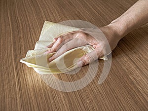 Hand with wet wipe cleaning table