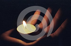 Hand in which there is a lighted candle