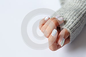 Hand on a white background and beautiful pearl manicure close up