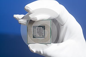 Hand in white glove holding a CPU computer processor microchip
