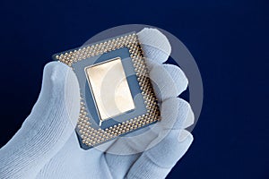 Hand in white glove holds a computer chip.