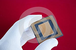 Hand in white glove holds a computer chip.