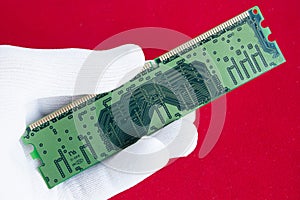 Hand in white glove holds a computer microchip.