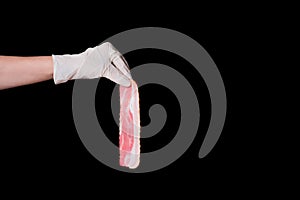 Hand in white protective glove holding long thin tasty pink piece of bacon isolated on black background. Food banner