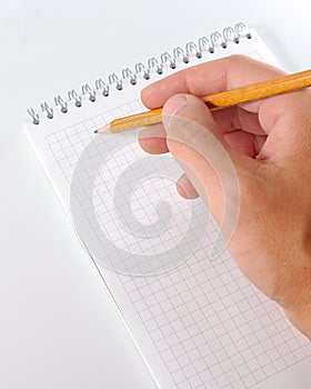 Hand whith pencil writing in notebook