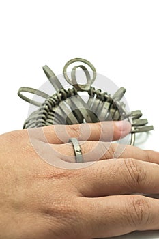 Hand wiith Jeweler finger sizing tools isolated
