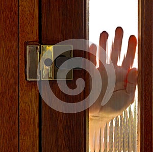 Hand on window in door