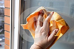 hand wipes window glass in high-rise city house