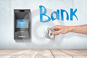 Hand withdrawing cash from ATM machine drawing
