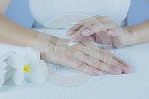 Hand of woman apply lotion on skin of back hand