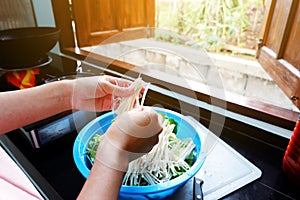 Hand of woman is Being prepared Flammulina velutipes Needle mushroom And vegetables In a bowl To prepare cooking food After