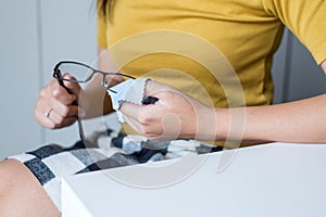 Hand woman cleaning her glasses with cloth,Clean lenses of eyeglasse
