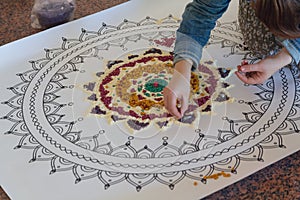 Hand of the woman creating a mandala