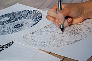 Hand of woman drawing yin yang for anti stress coloring book