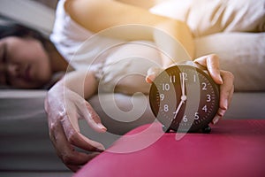 Hand woman hates getting stressed waking up early,Female stretching her hand to ringing alarm to turn off alarm clock