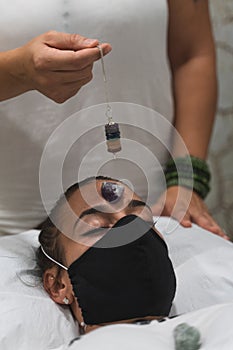 Hand of a woman healer applying reiki and energy therapies through the use of a pendulum photo