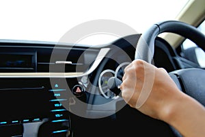 Hand of the woman hold the control wheel and drive the car