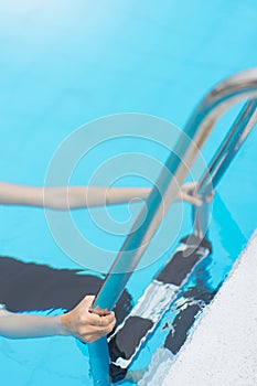 Hand woman hold grab bar in swimming pool.