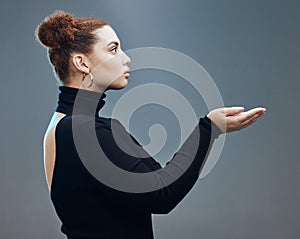 Hand, woman and holding gesture in studio with mockup, space and grey background for product placement. Young, beautiful