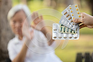 Hand of woman holding medicine tablets,capsules,show lots of  medication,old elderly on blurred background,senior people raise